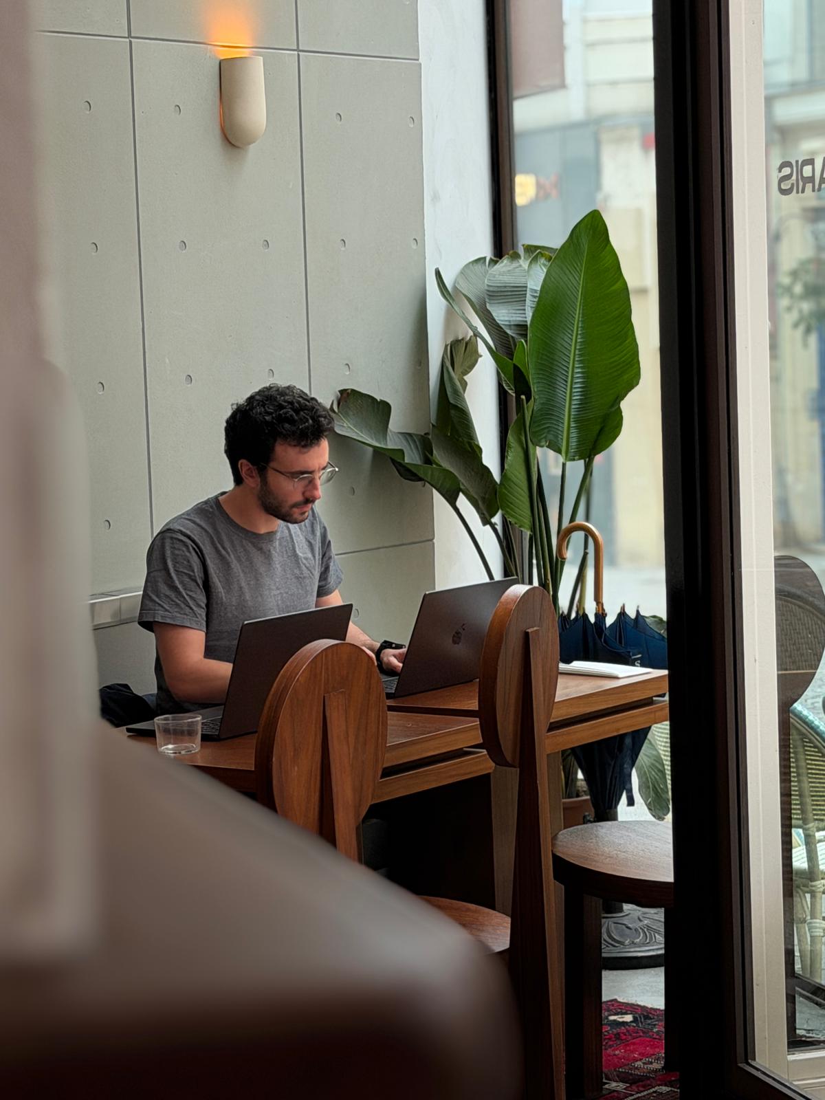 Gabriel Amzallag working on a laptop in a Paris café